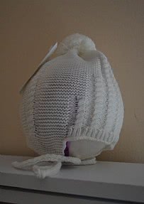 Gorro bebé de lana con pompóm en color crudo.