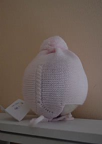 Gorro bebé de lana con pompóm en color rosa.