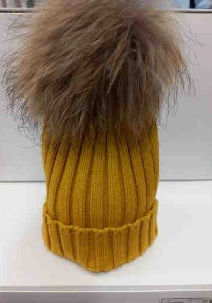 Gorro con pompóm de pelo natural en color mostaza.